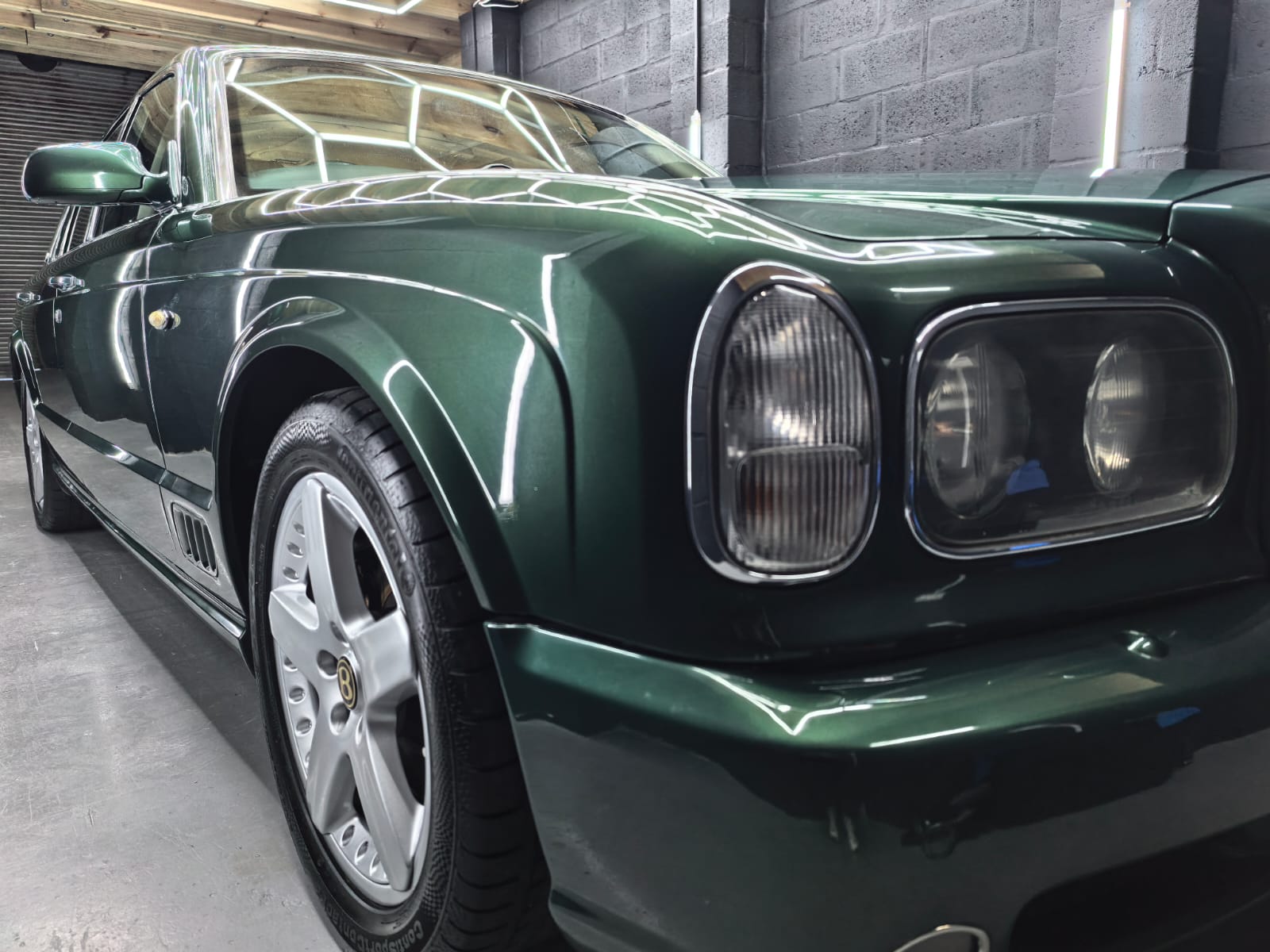 Green Bentley front quarter after premium detailing