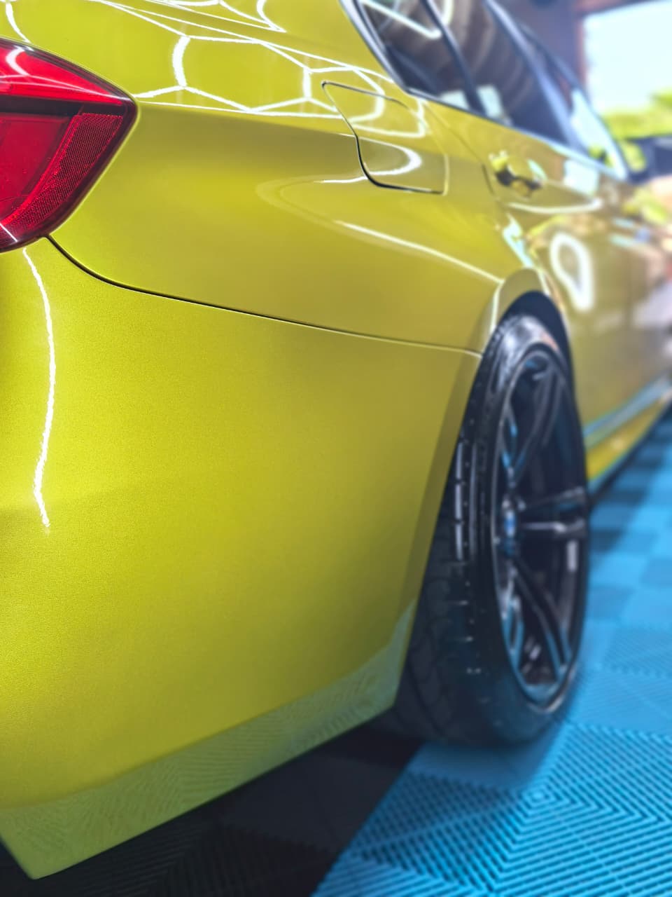 Yellow vehicle rear quarter panel after cosmetic body repair