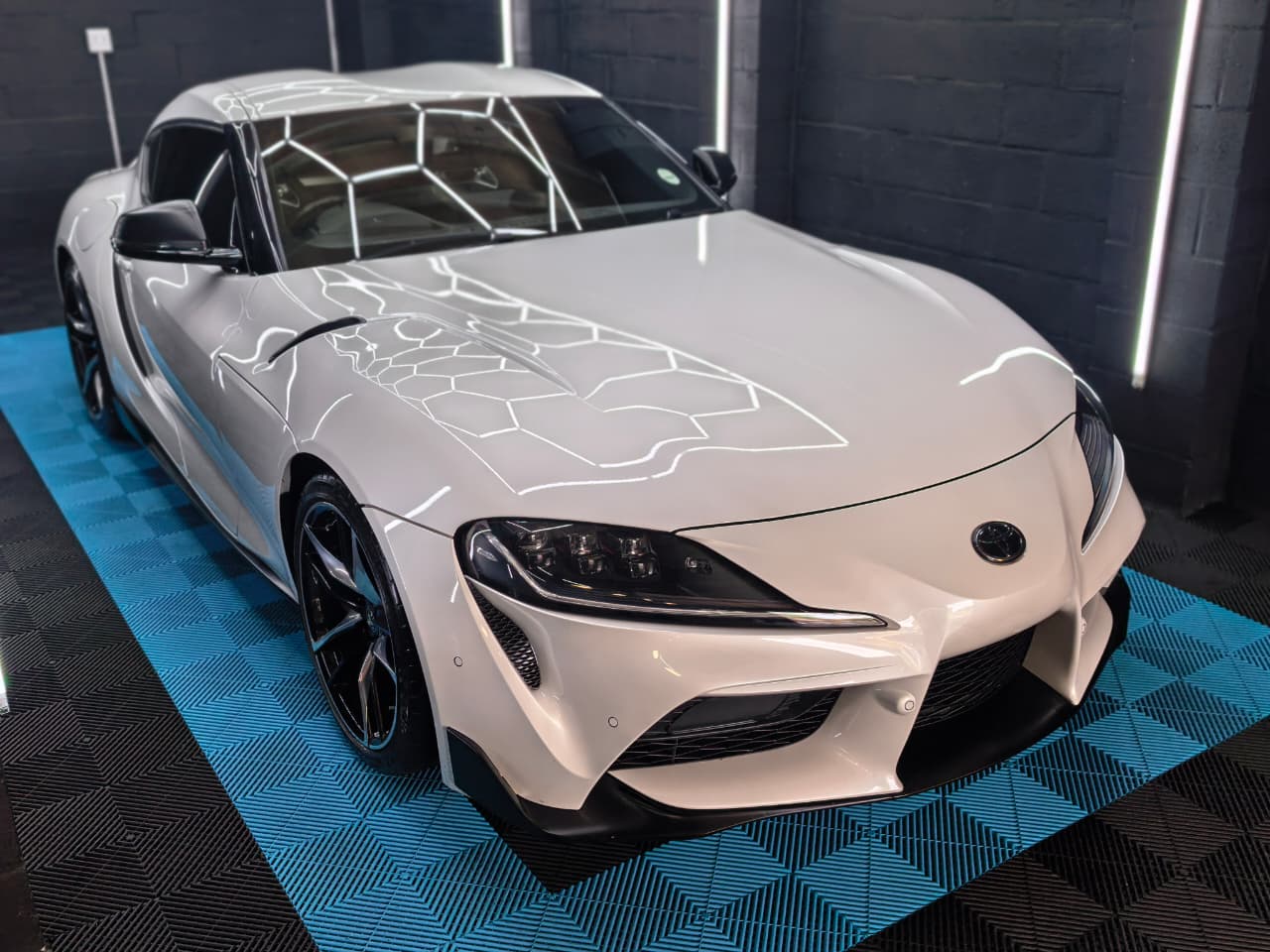 White Toyota Supra in the AutoHubCPT detailing studio